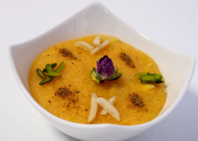 Safran-Reispudding mit Zimt, Pistazien und einer Rosenblüte